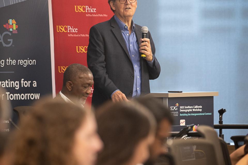 Man speaking at podium during a conference.